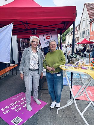 2 Frauen stehen an einem bunten Stand