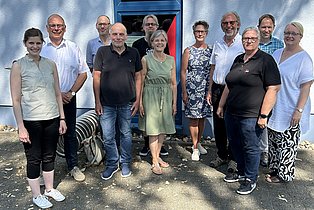 eine Gruppe von Menschen steht vor einem Gebäude